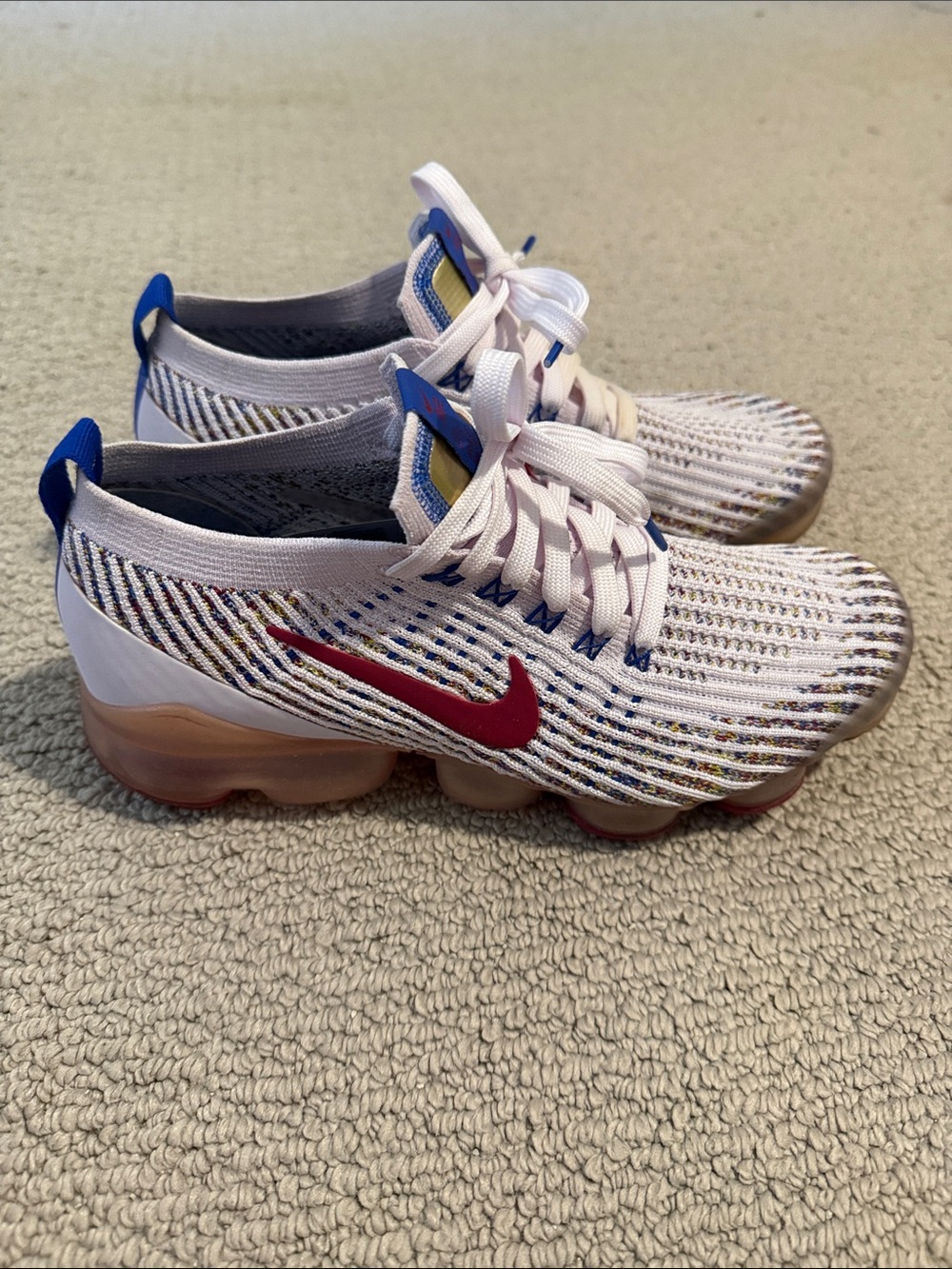 Nike White Flyknit VaporMax Sneakers with Red Swoosh and Blue Accents